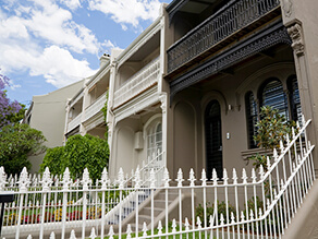 Brown Neutral Townhouse with Black Fencing and Fretwork with Black Door and Garden